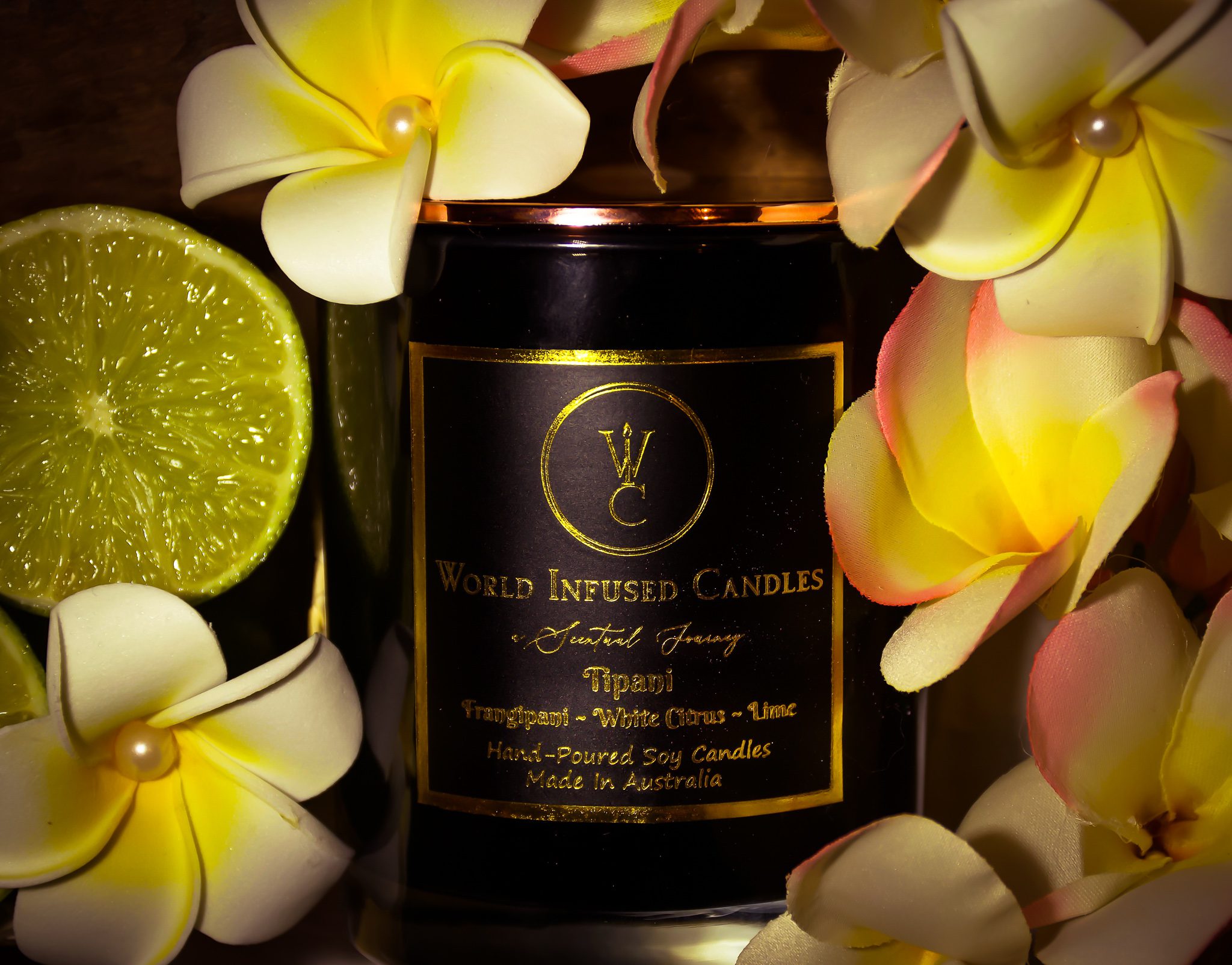 Tipani soy candle surrounded by lime and frangipani flowers